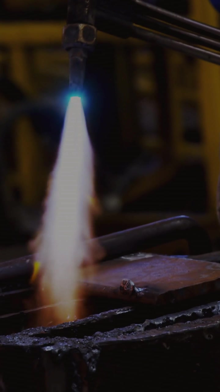 Vertical video: Technician igniting torch, heating metal plate for repair, terminal text overlaying