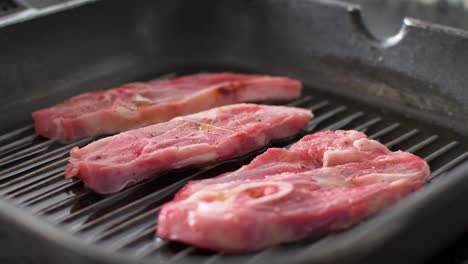 Close-up-view-of-seasoned-lamb-chops-cooking-on-a-grilled-pan