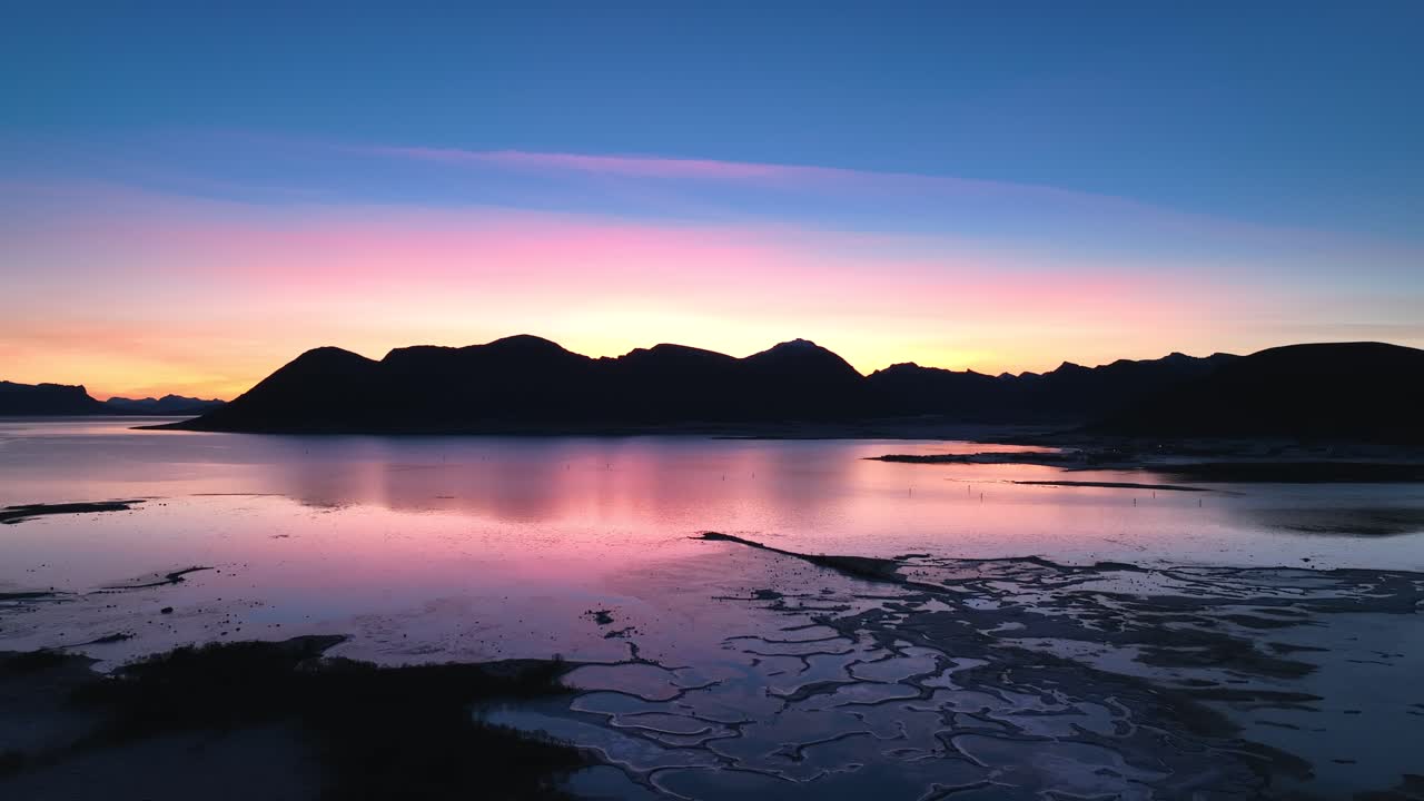 Aerial footage of Bleik, Andøya, showcasing steep cliffs, fjords, and the ocean during golden hour. Capturing the serene beauty of Arctic landscapes with vibrant sunset hues.