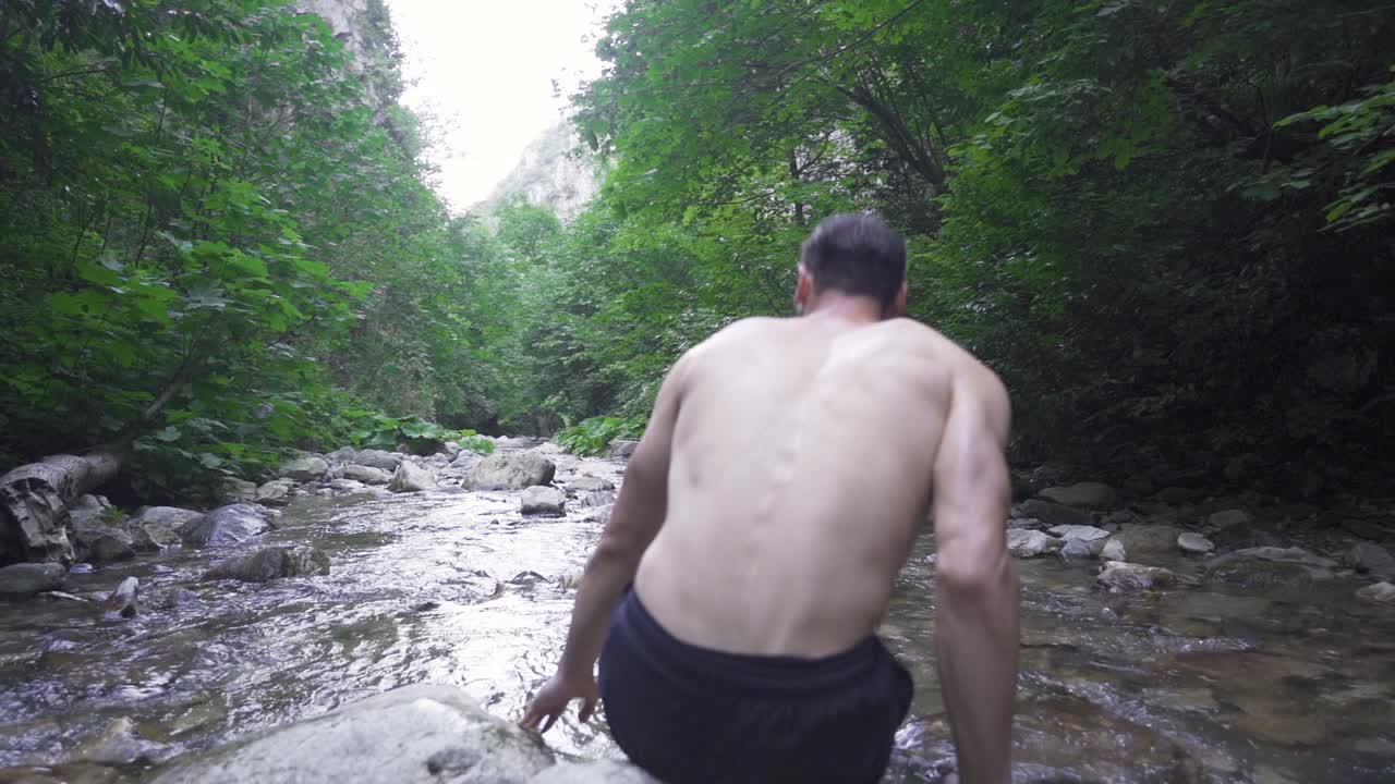 하천에 머리카락을  ⁇ 는 사람. 슬로우 모션.