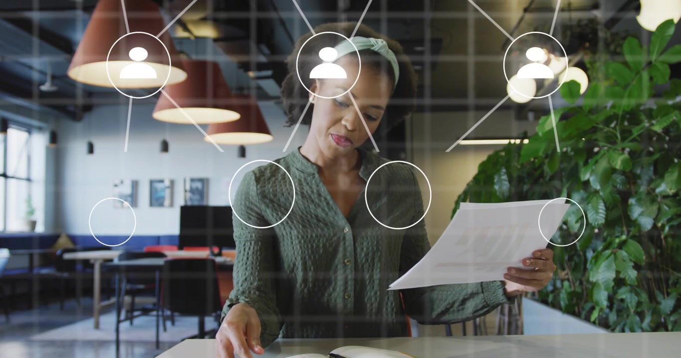 Female office worker reading paper and causing animated network icons mapping business connections