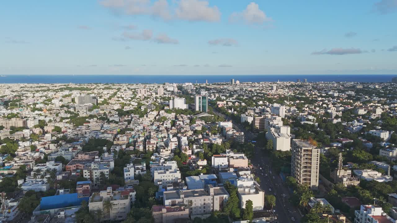 An aerial perspective of Chennai's Mount Road in the morning would showcase the city's bustling energy. The sun would cast a golden glow over the Bay of Bengal