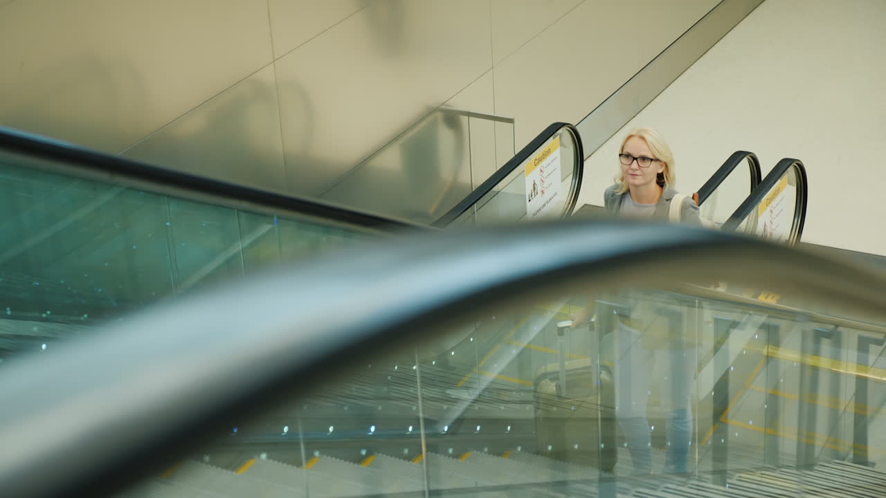 mujer en viaje de negocios monta escaleras mecánicas