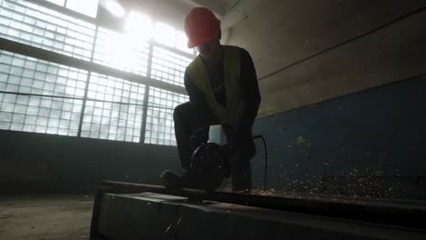 construction worker cuts steel with a circular saw, construction worker's feet, flying sparks from a circular saw. wide slow motion