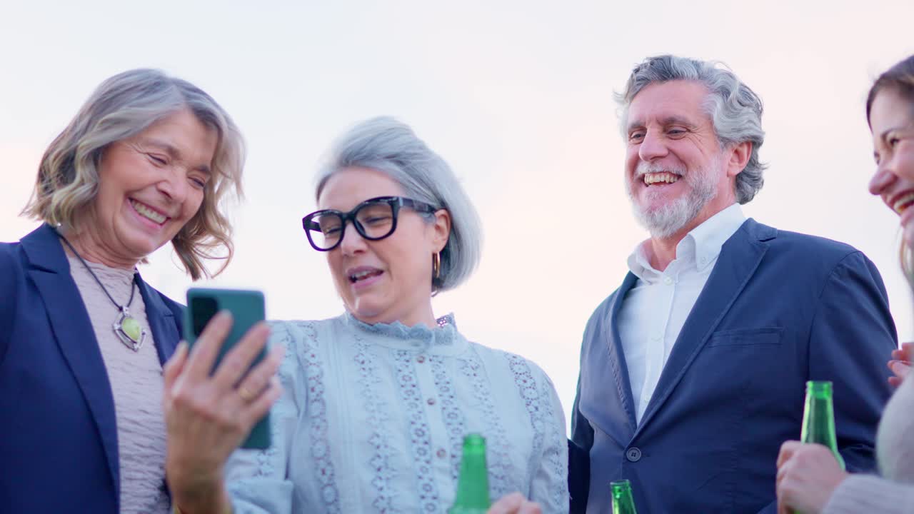 Allegro gruppo di amici che fanno selfie e bevono birra all'aperto