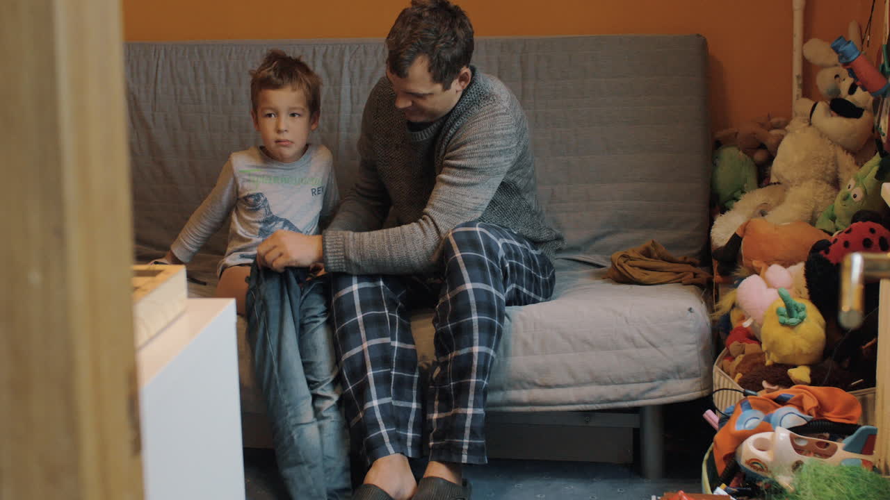 papá vistiendo al niño.