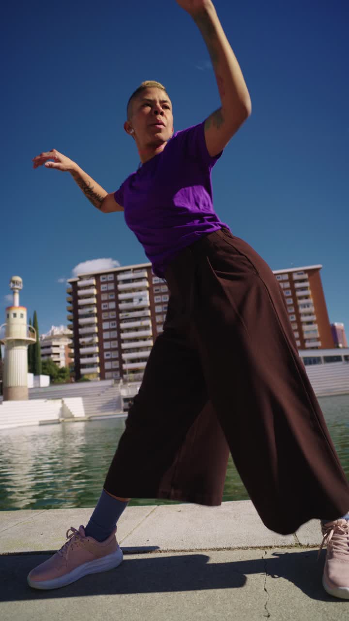 Energetic Woman Performing Street Dance Moves Outdoors by a Lake