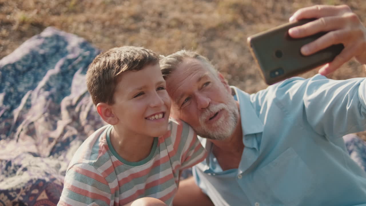 Nonno e nipote felici che si fanno un selfie all'aperto