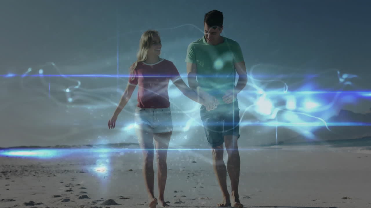 couple walking barefoot on beach, featuring digital light overlays and wave patterns for marketing