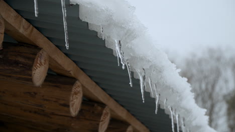 water dripping from icicles hanging on the roof of house