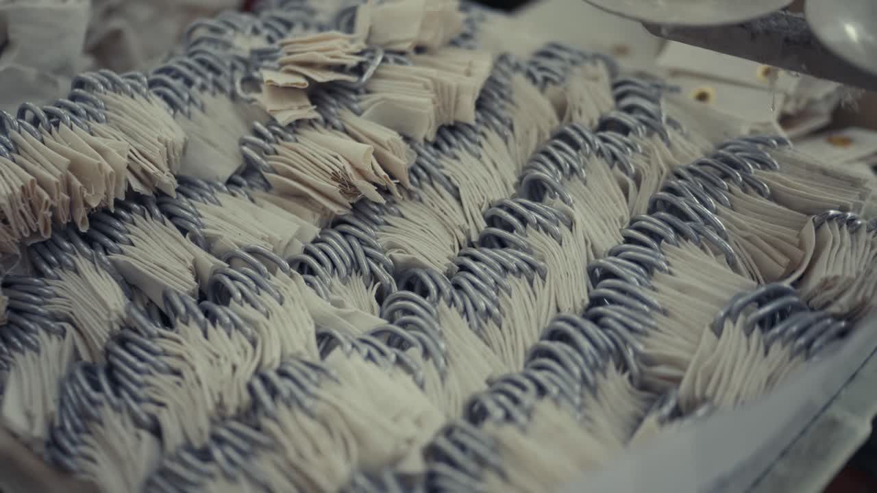 Detail of tent metal rings sewn in Sialkot factory, mass production process in textile industry, industrial craft and assembly line