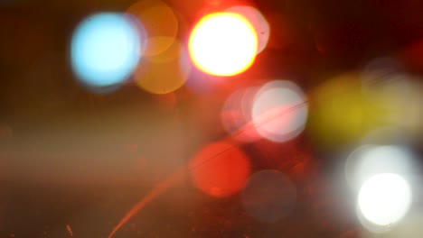 a blurred shot of car indicators, traffic lights and headlights taken from inside a car