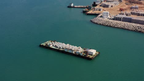 barge carrying concrete blocks in a port