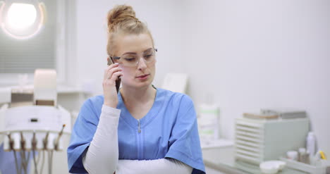 Female-Doctor-Talking-On-Mobile-Phone-At-Healthcare-Clinic-1