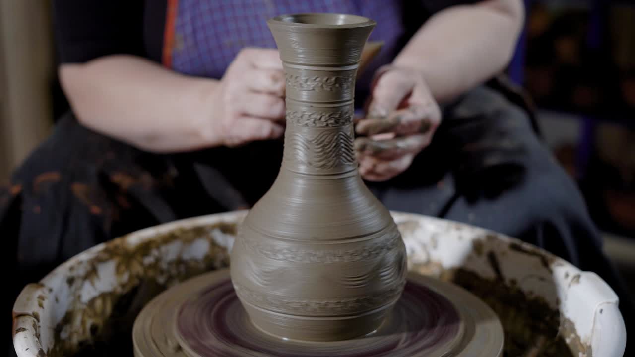 close up shot of a woman's hands who works in the workshop, a professional craftsman creates clay ware on a potter's wheel
