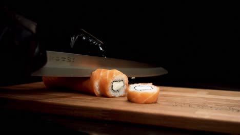 el chef de sushi cortando el rollo de salmón.