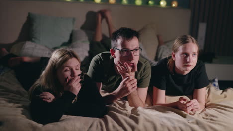 family watching movie in bed