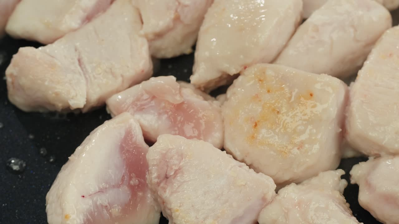 Man slicing raw turkey or chicken meat fillet on oak cutting board closeup, cooking with knife on restaurant kitchen. High quality 4k footage