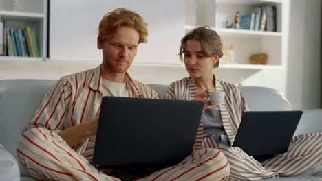 smiling boyfriend surfing internet enjoying morning coffee with girl closeup.