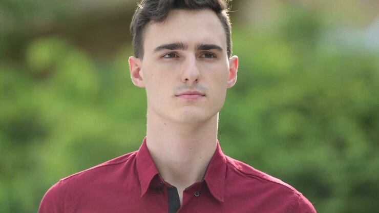 Young handsome businessman thinking in the streets outdoors