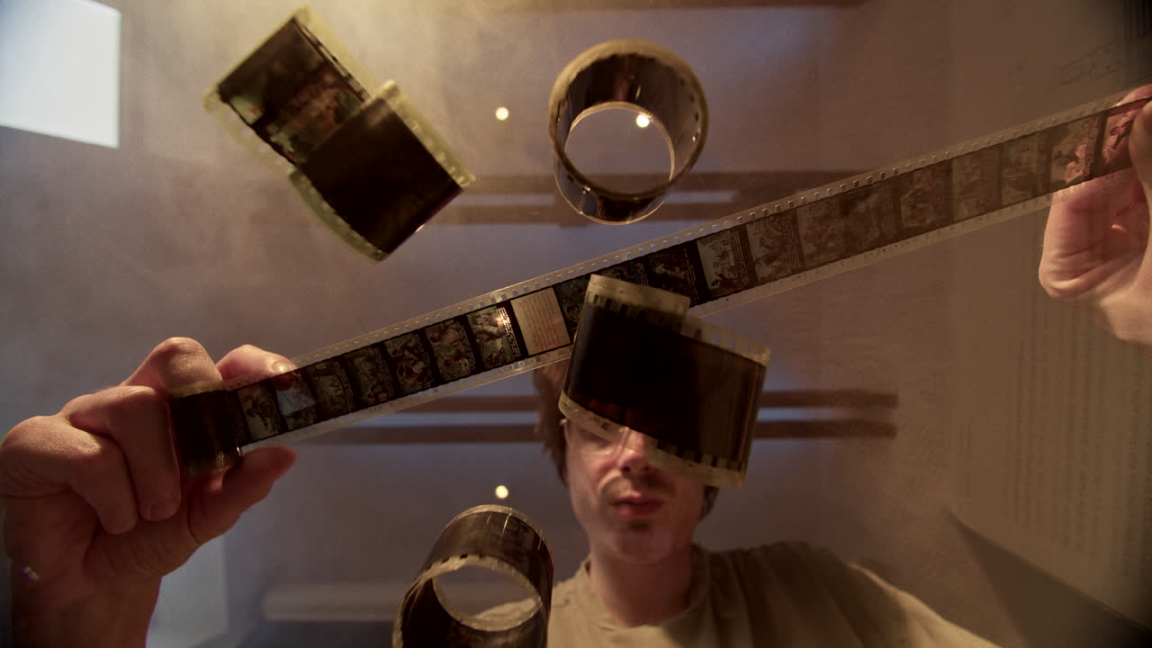 Man Inspecting Old Film Strips and Reels