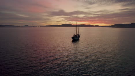 Vista-Panorámica-De-Un-Barco-De-Pesca-Tradicional-En-Medio-Del-Océano-Sereno-Durante-La-Puesta-De-Sol-Cerca-De-La-Ciudad-De-Kuah-En-La-Isla-De-Langkawi,-Malasia