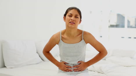 mujer atractiva que sufre de dolor de vientre