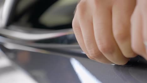 close up mechanic taking off chrome strip of car, shallow focus