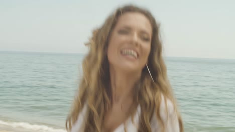 mujer europea de espíritu libre con el cabello suelto baila en la playa sin inhibiciones