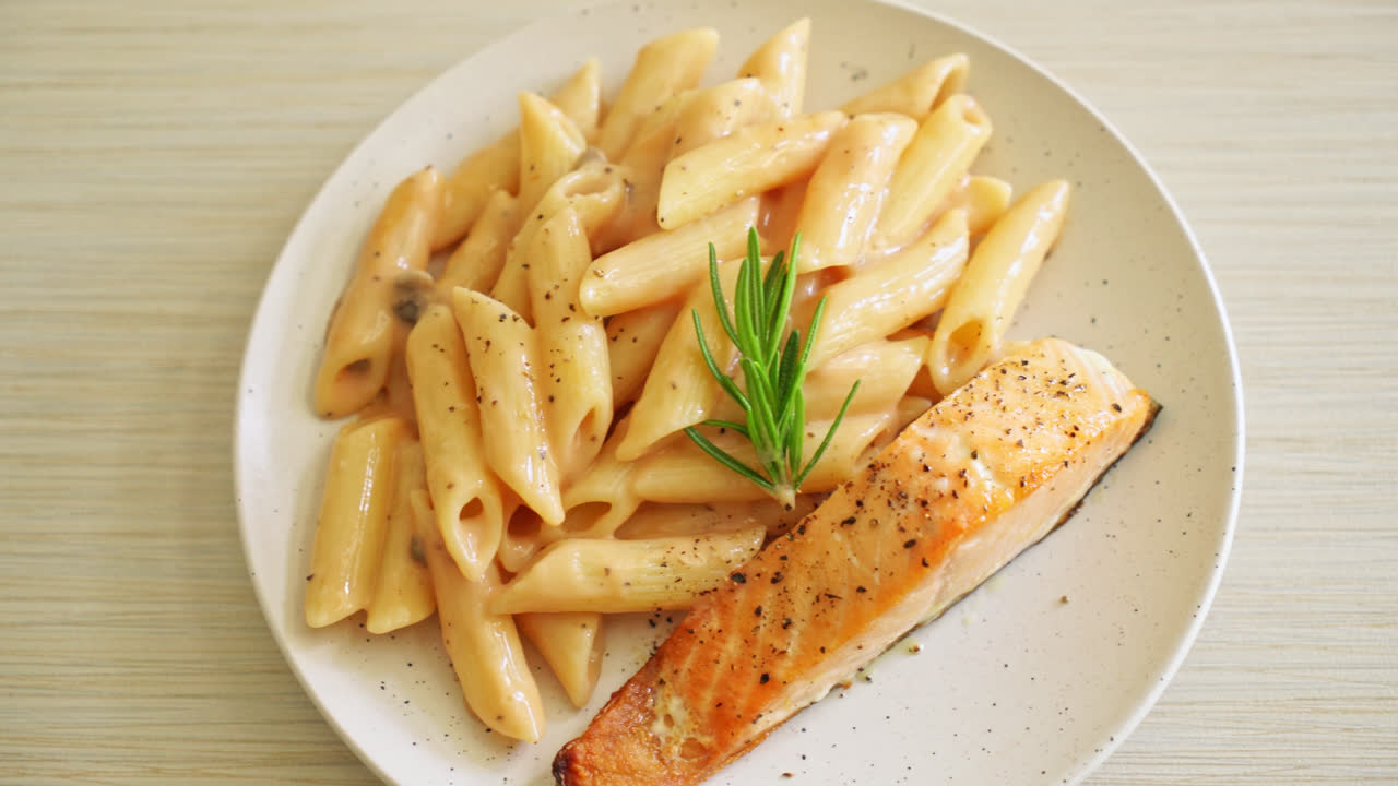 gegrilltes Lachsfilet mit Penne-Nudeln und Tomaten-Sahnesauce
