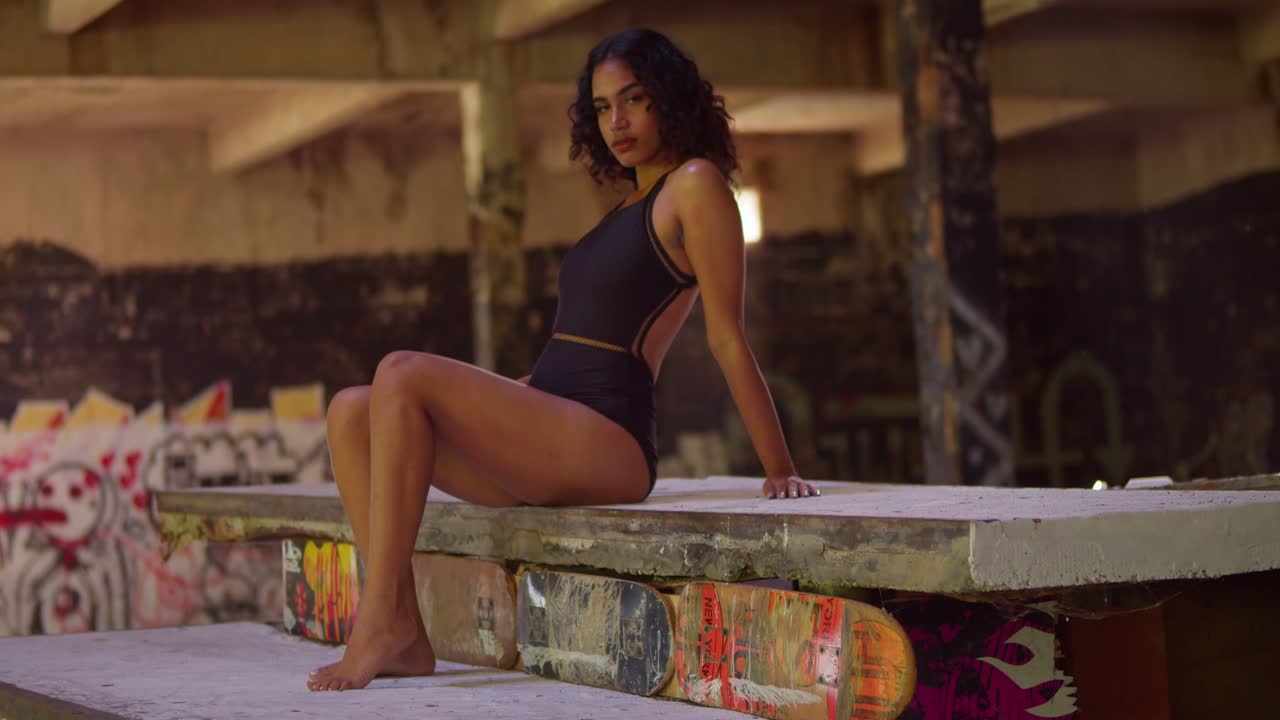 Una giovane ragazza in bikini si sta godendo il suo tempo all'interno di uno spazio interno pieno di graffiti