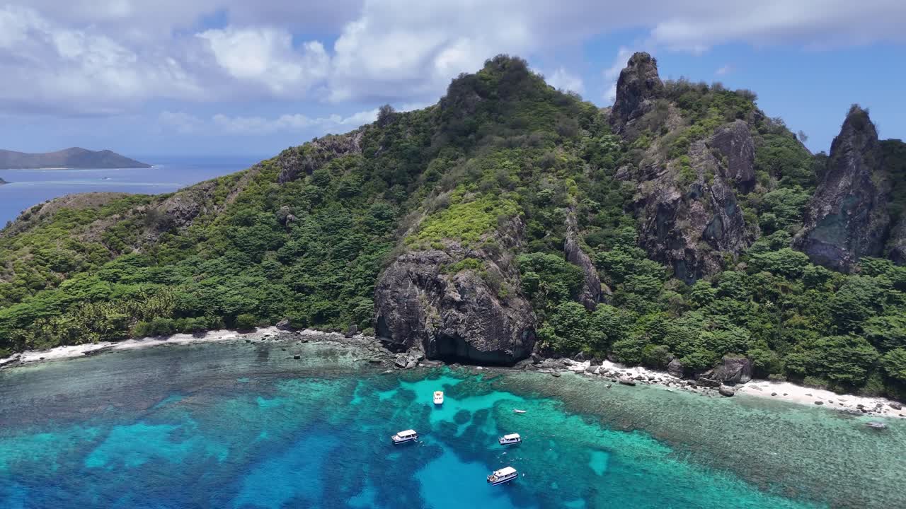 Spettacolare vista aerea da drone del lussureggiante paesaggio montuoso di Castaway Island nelle Fiji. Spiagge incontaminate di sabbia bianca e acque turchesi circondano questo paradiso del Pacifico meridionale.