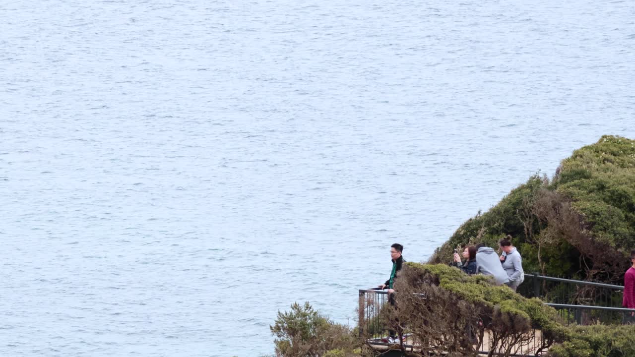 관광객 들 이 전망대 에서 바다 의 경치 좋은 전망 을 감상 하고 있다
