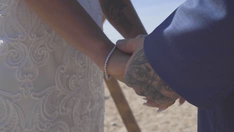 bride and groom holding hands at ceremony