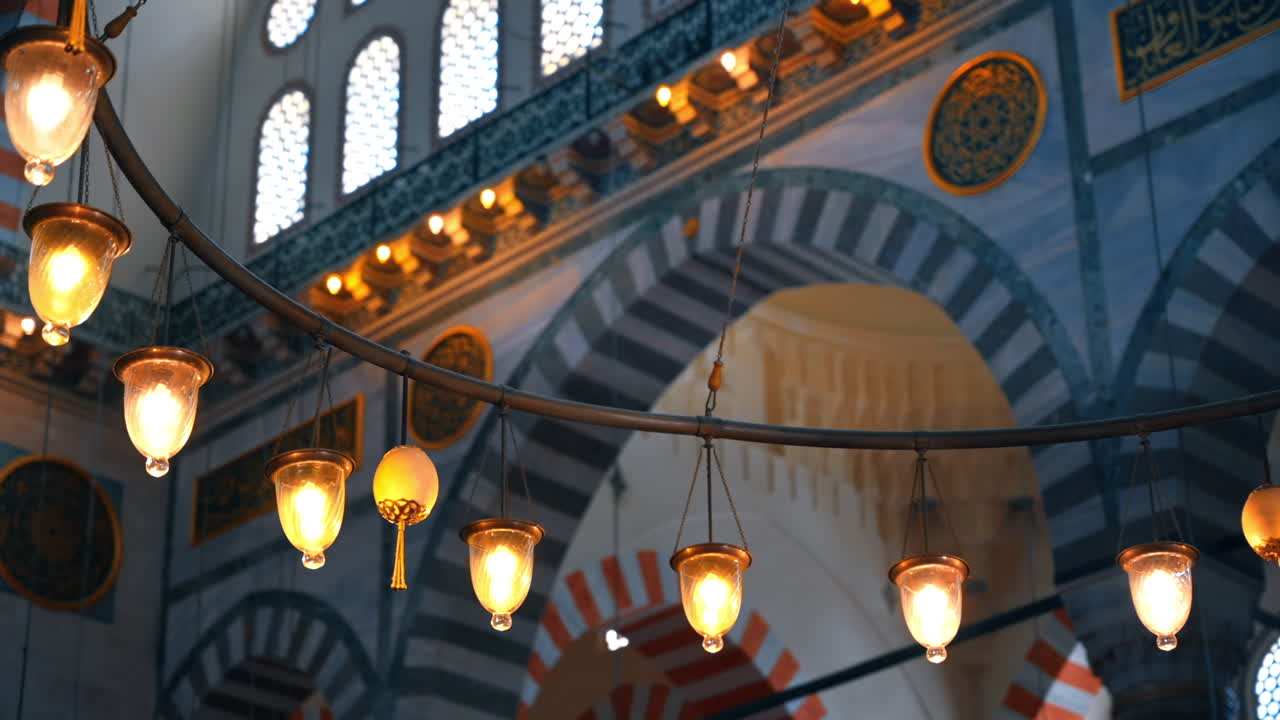 Close view of lamps inside the Suleymaniye mosque in Istanbul, Turkey. Illumination, painted walls
