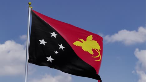 flag of papua new guinea moving in the wind with a clear blue sky in the background, clouds slowly moving, flagpole, slow motion