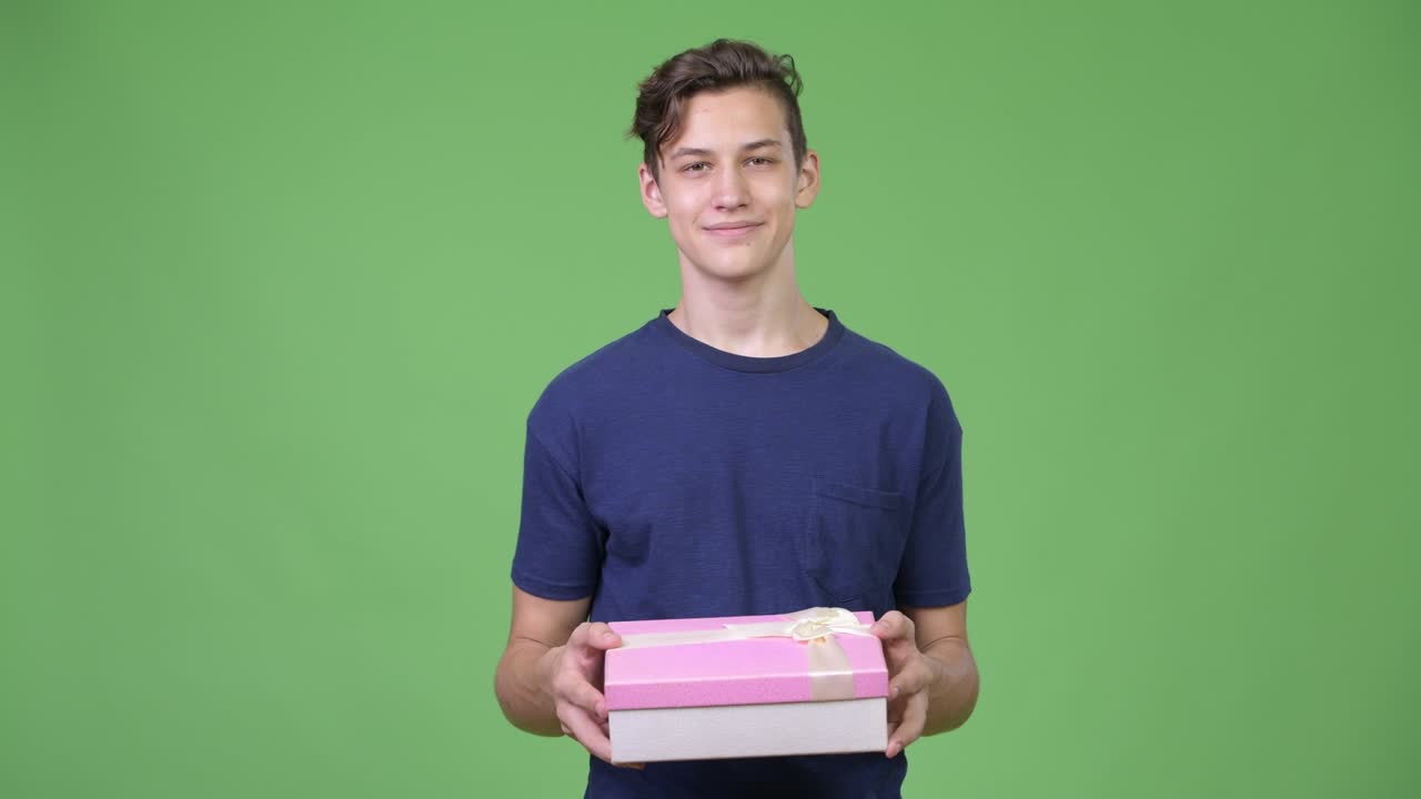 Young handsome teenage boy with gift box
