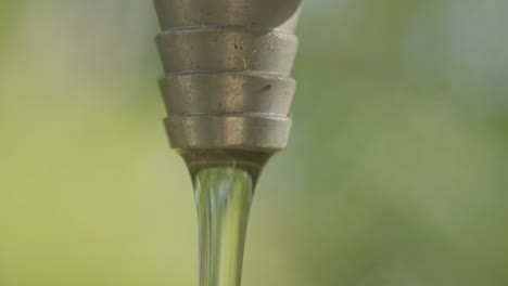 water pouring out of a metal tap in slow motion