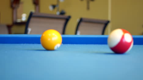 pool balls rolling around on blue felt billiards table