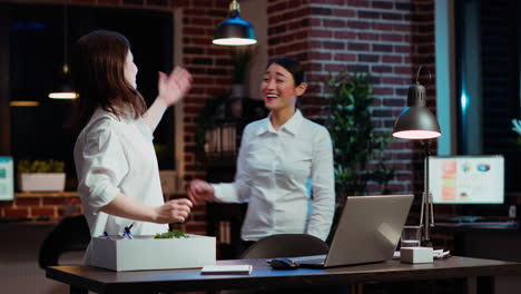 woman packing desk belongings, excited to change offices after being promoted