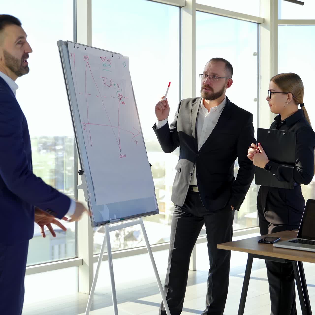 Conversation between business people. Group of successful entrepreneurs arguing in modern office room with large windows in the city