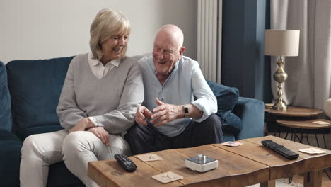 elderly couple laughing while playing scrabble