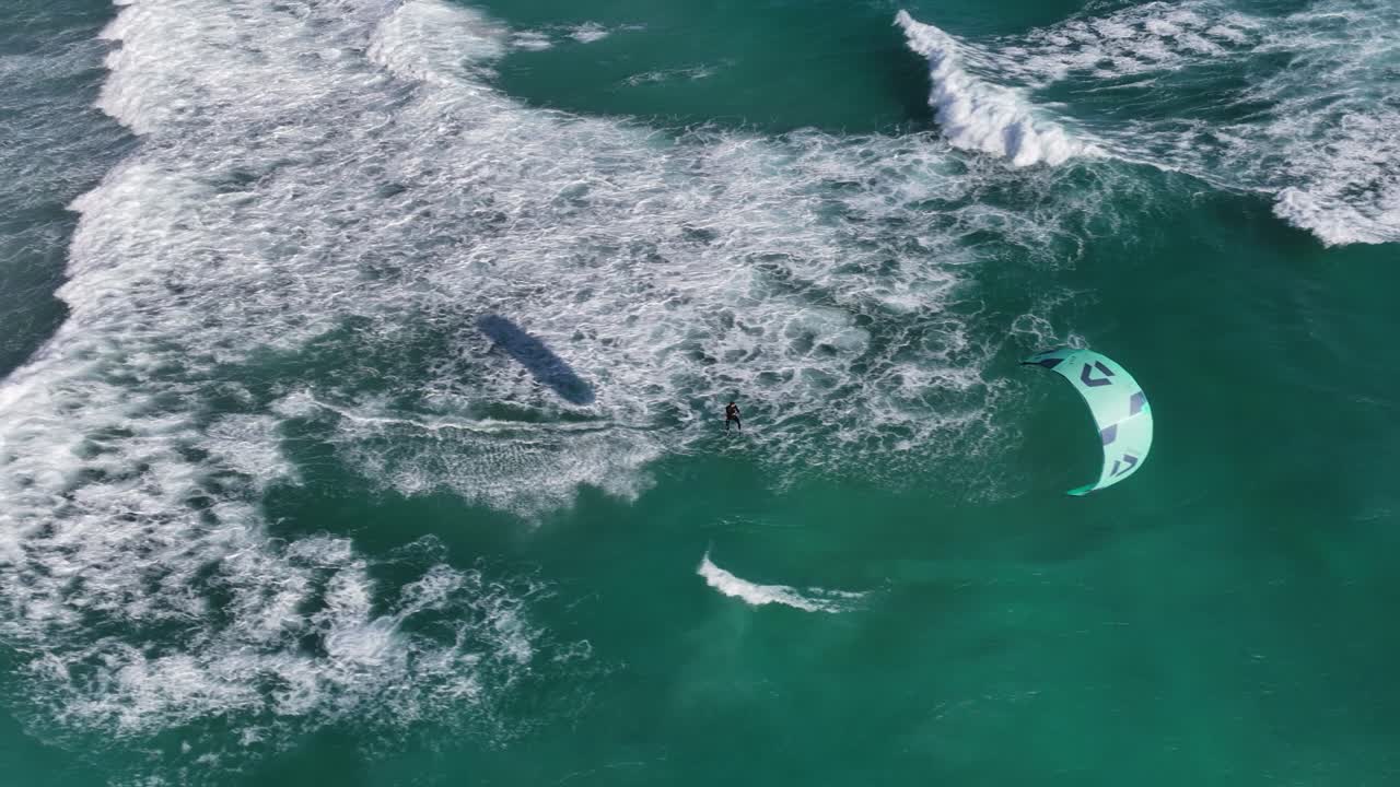 거친 청록색 파도와 바람이 부는 아프리카 날씨 속에서 카이트 서퍼 항해