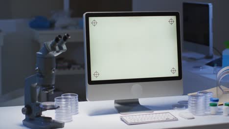 computadora de escritorio con pantalla iluminada en una estación de trabajo en un laboratorio vacío