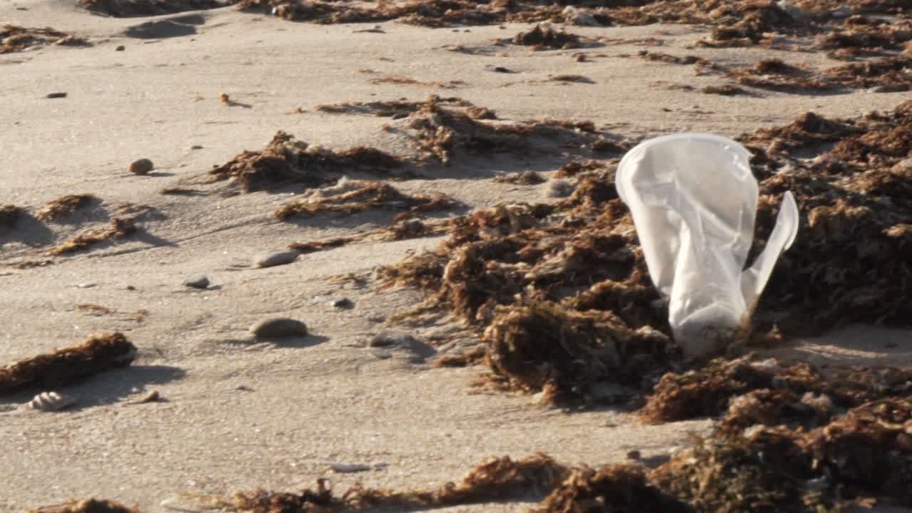 해변에 던져진 오래된 플라스틱 병