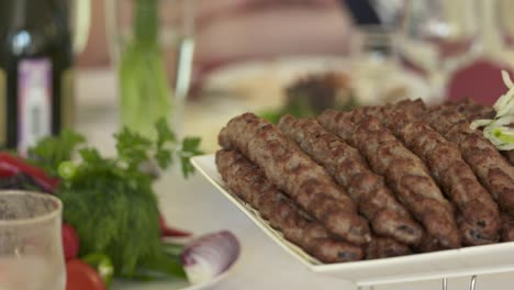 armenian lula kebab served with chopped onion on dinner table in restaurant