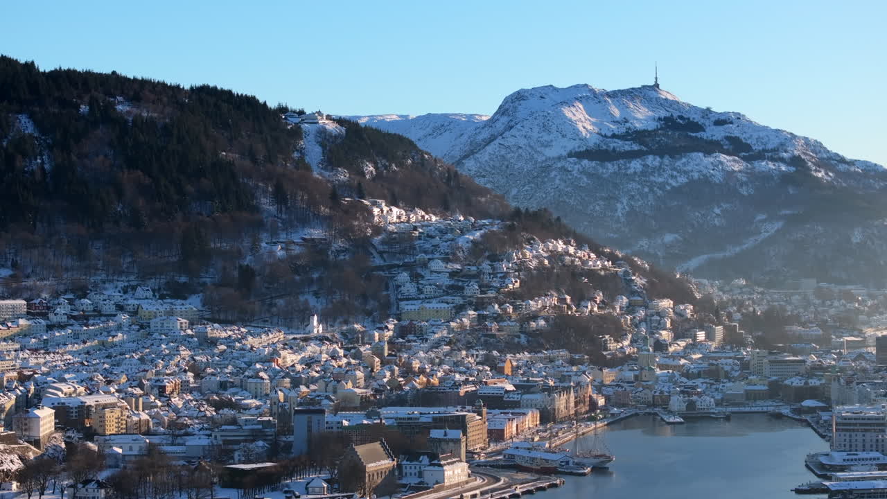 Aerial shot of Bryggen, the waterfront and the old houses in Bergen covered in snow on a winter day