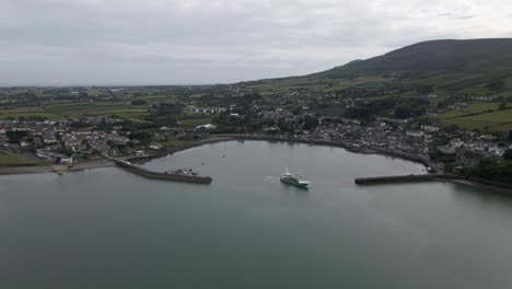 toma de un dron de un barco de pesca que zarpa desde un pequeño pueblo