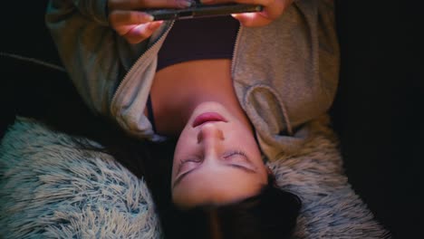 teenage girl relaxing on a cozy couch, intently using her smartphone. warm natural lighting enhances the tranquil and casual atmosphere.
