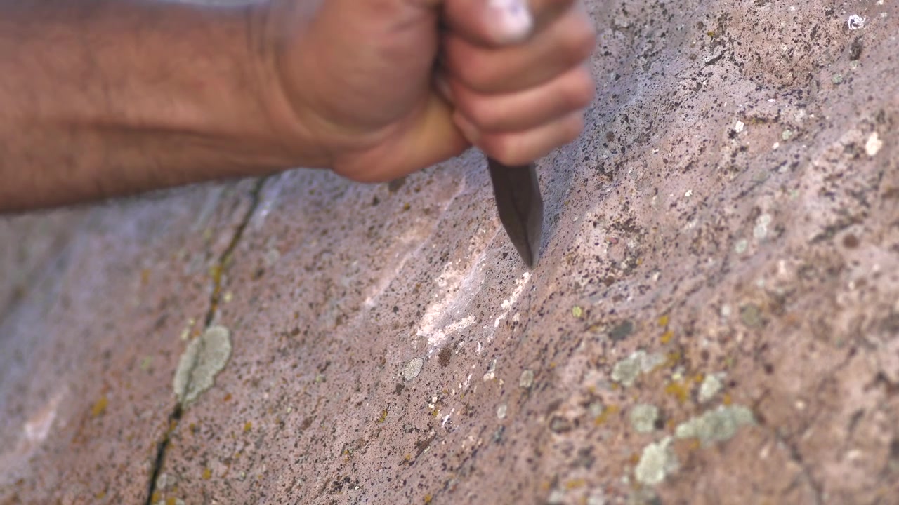 Artesão Esculpindo Petróglifos em Superfície de Pedra Natural